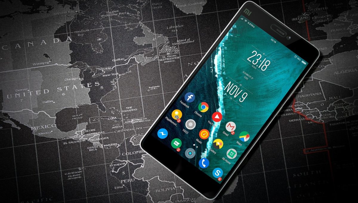 橘子tv App 主界面在手机上亮起的画面，深色背景里分类标签与封面卡片整齐排开